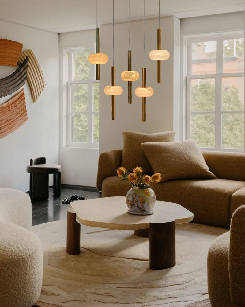 Modern living room with brown sofa, round wooden coffee table, and pendant lights.