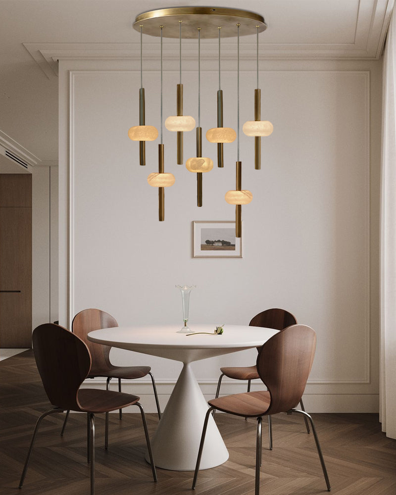 Dining room with a modern chandelier, white table, and brown chairs.