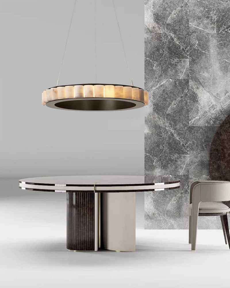 Contemporary round table with striped chandelier and marble wall backdrop.