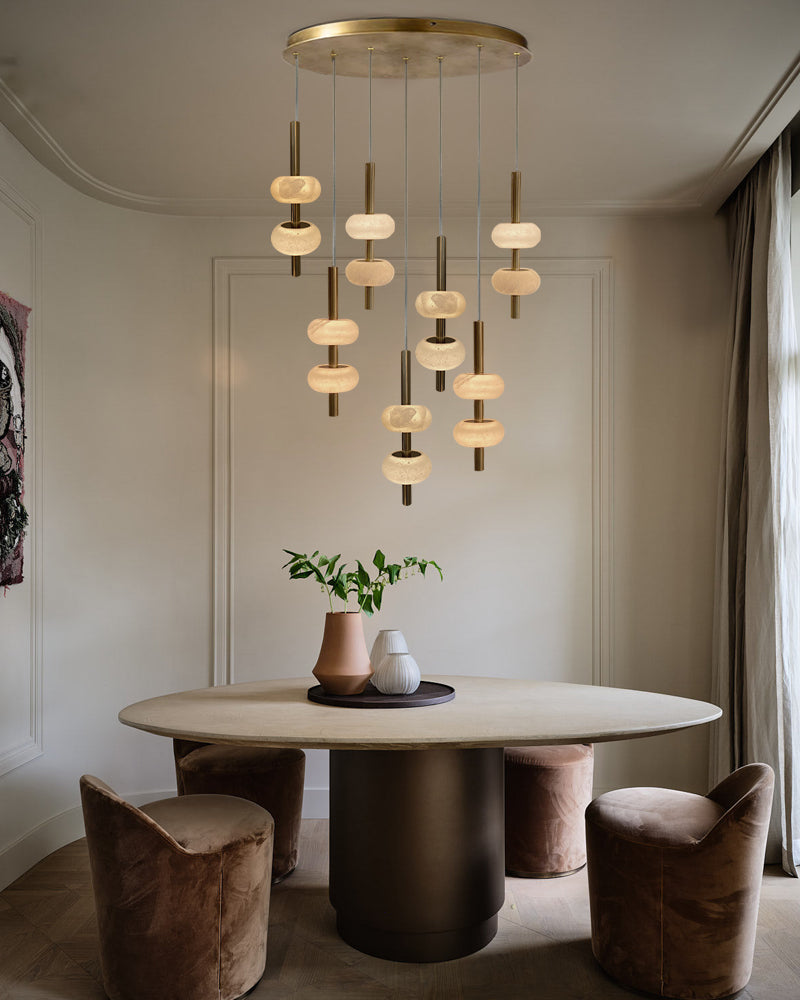 Modern dining room with a chandelier, round table, and chairs.