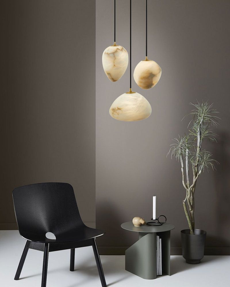 G9 Nature Alabaster Pebble pendant lights above a modern black chair and minimalist decor.