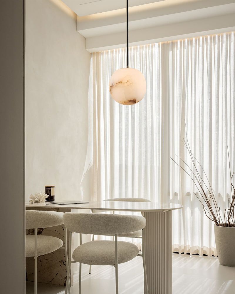 Elegant marble pendant lamp illuminating a modern dining area with soft textures