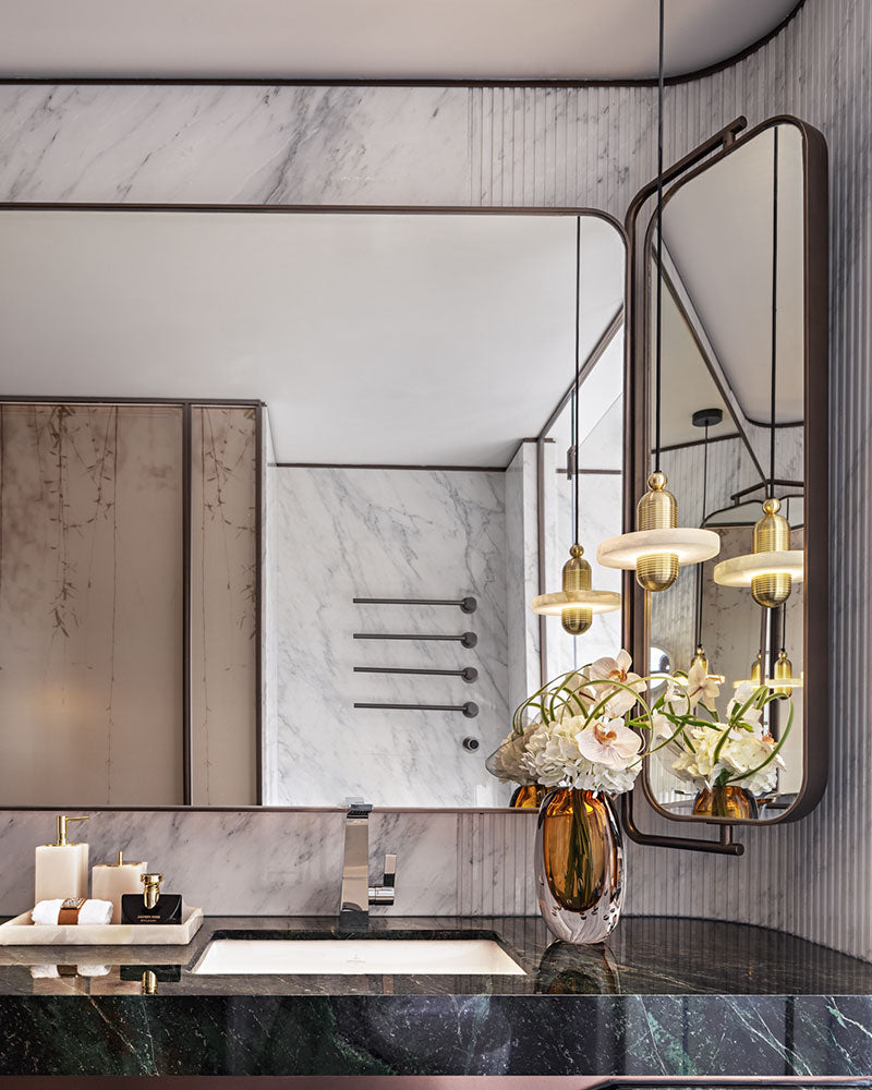 Gold pendant lamp above marble sink in luxury modern bathroom