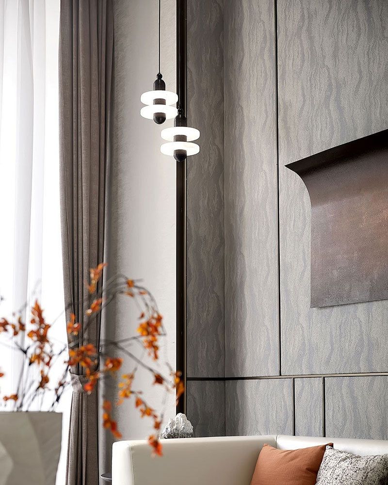 Two-tier modern pendant lamp illuminating stylish living room with soft decor.