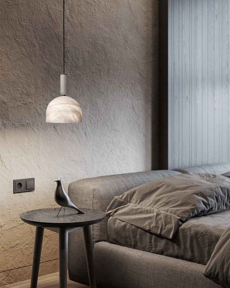 Modern white marble pendant light above a cozy bed in a stylish bedroom