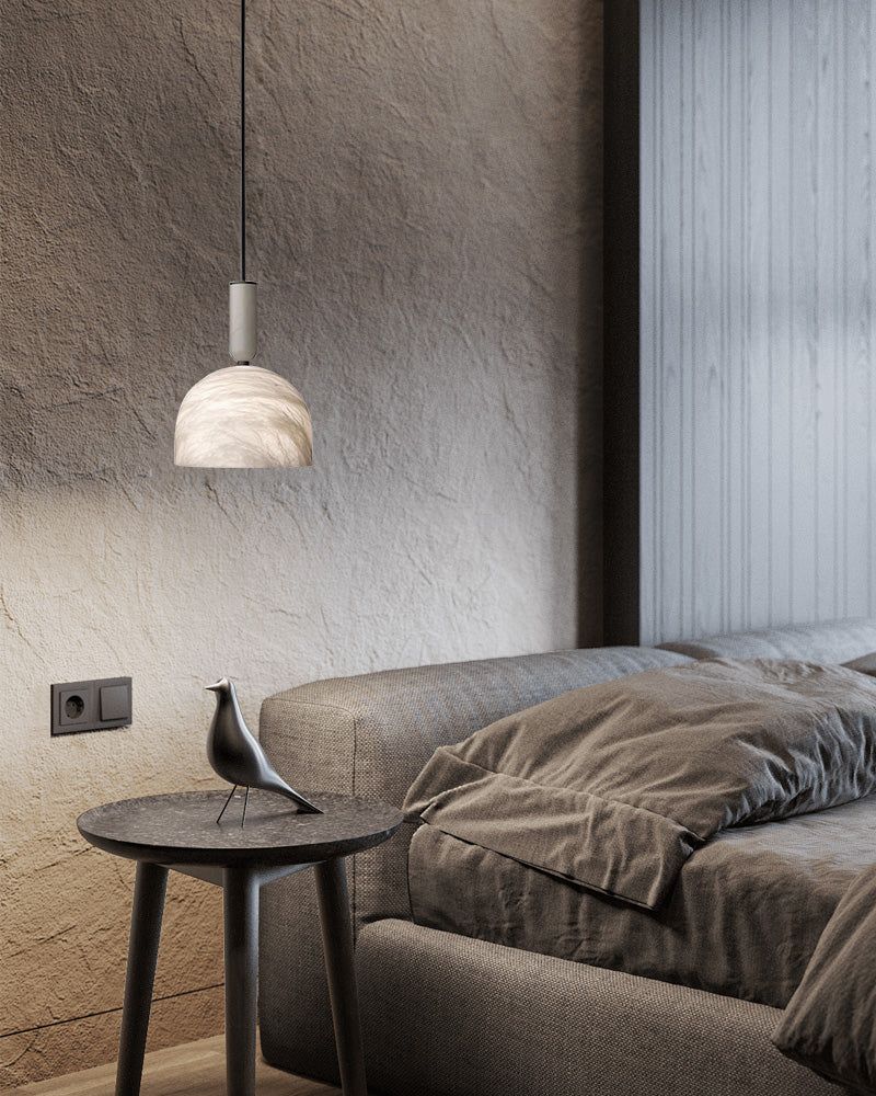 Modern white marble pendant light above a cozy bed in a stylish bedroom