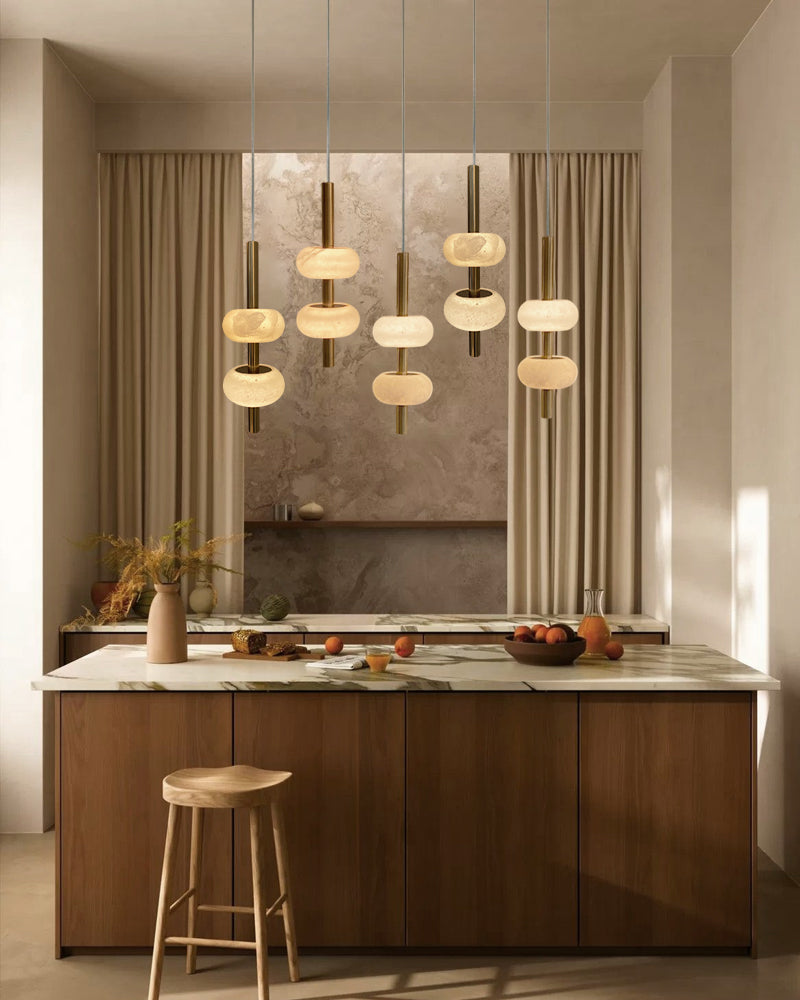 Modern kitchen with pendant lights, wooden island, and bar stool.