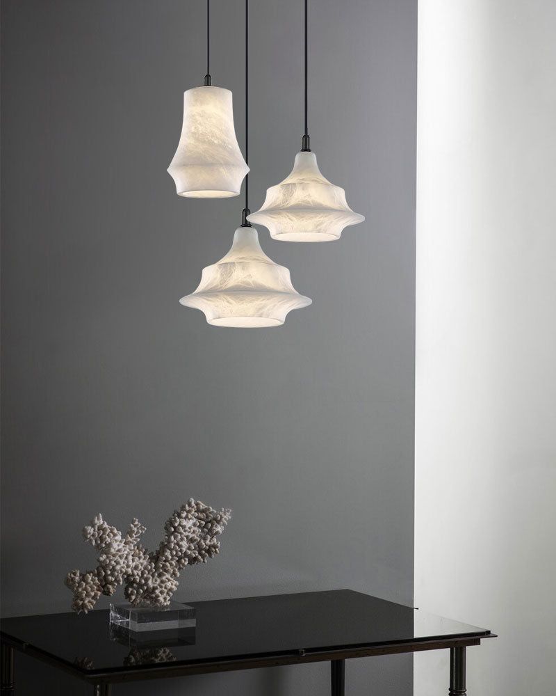 Unique alabaster pendant lamps above a sleek black table with floral decor.