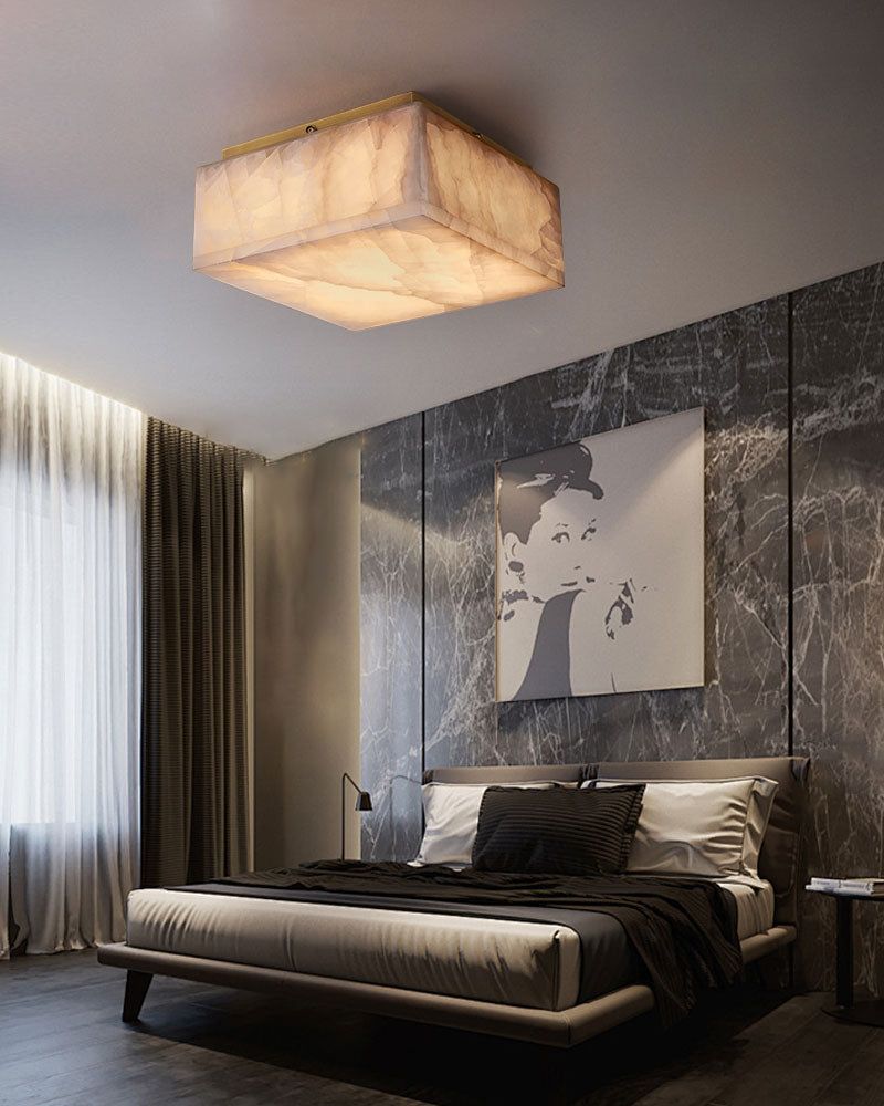 Square alabaster ceiling light illuminating a contemporary bedroom with sleek decor.