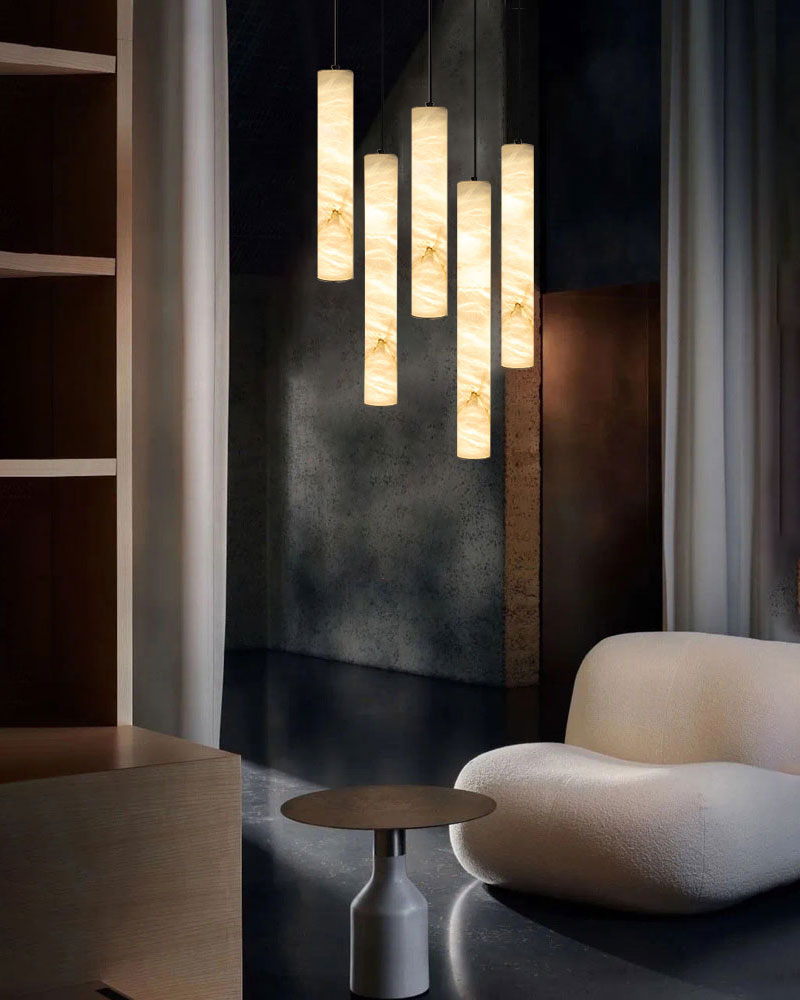 Alabaster cylindrical pendant lamps in stylish living room setting.