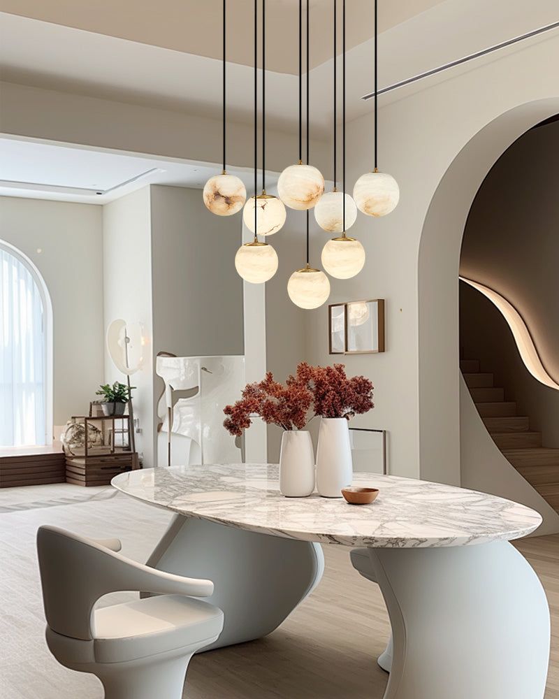 Marble pendant lamp cluster above a modern round marble dining table in a stylish interior