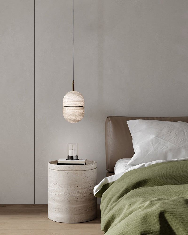 Minimalist alabaster pendant light above a modern bedside table in a serene bedroom