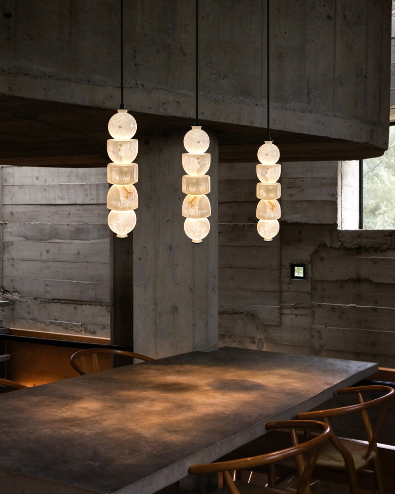 Globe pendant light set with stacked alabaster-style glass shades on black rods
