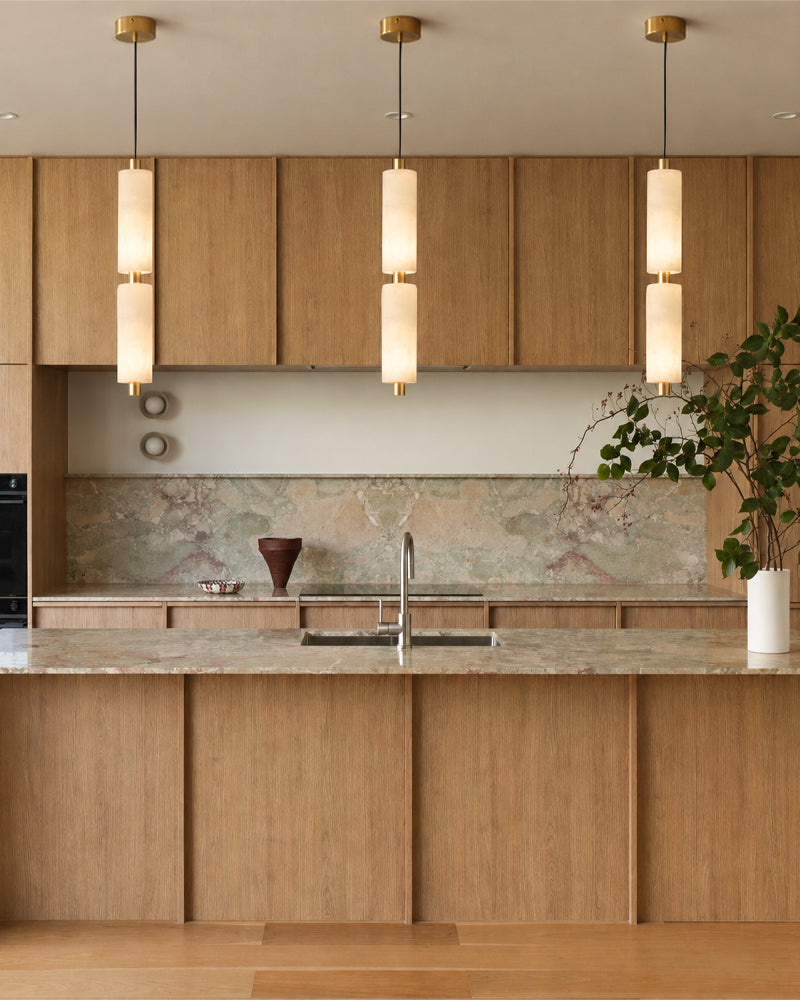 Multi-pendant ceiling cluster with brass trim and vertical alabaster cylinder shades