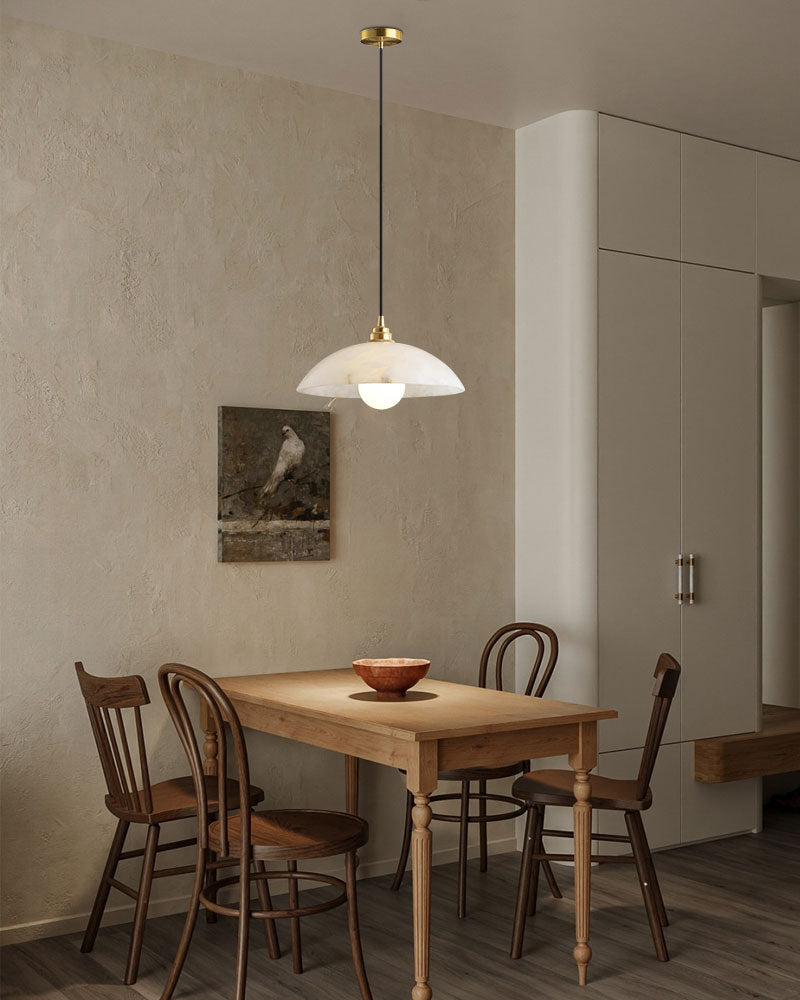 Cozy dining area with natural stone pendant lamp over wooden table and chairs.