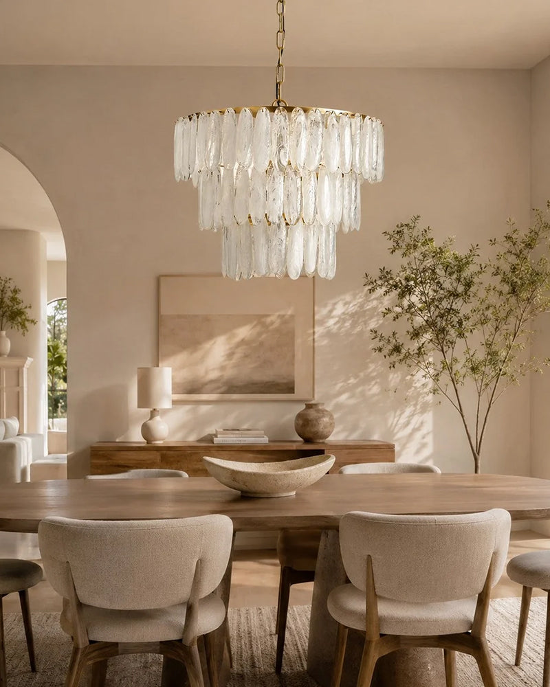 Multi-tiered clear glass chandelier with hanging clear glass drops and warm light