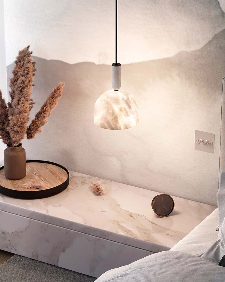 Postmodern white marble pendant light illuminating a stylish bedroom nightstand.
