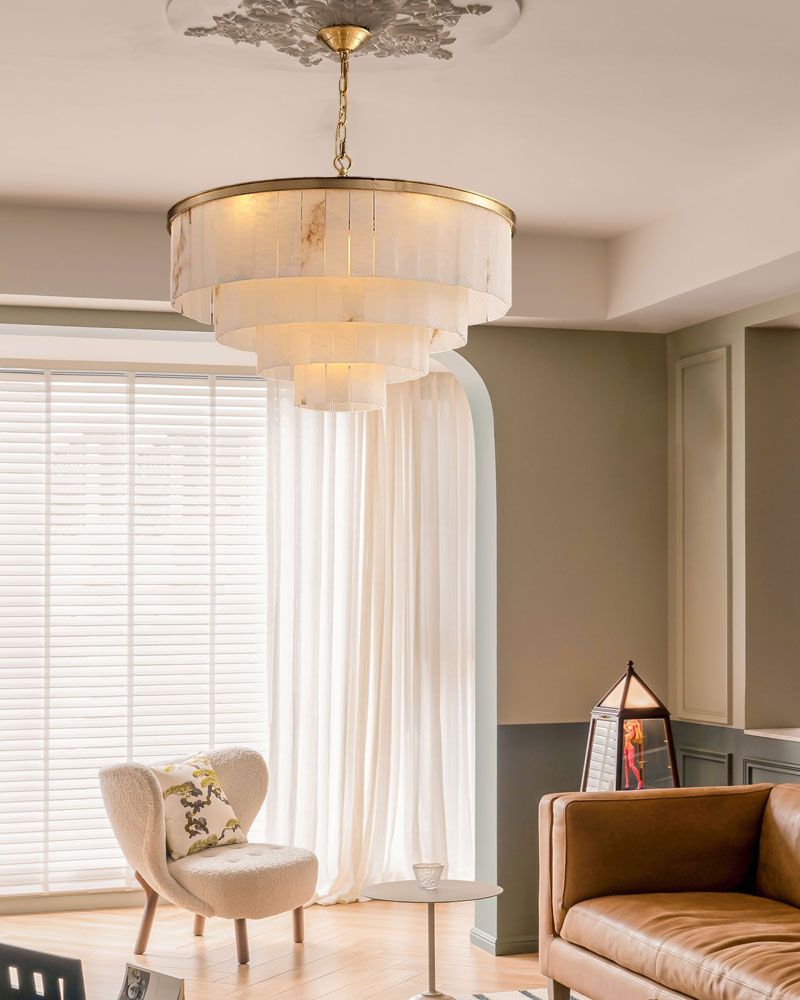 Brass-alabaster chandelier in a stylish living room with elegant armchair and natural light