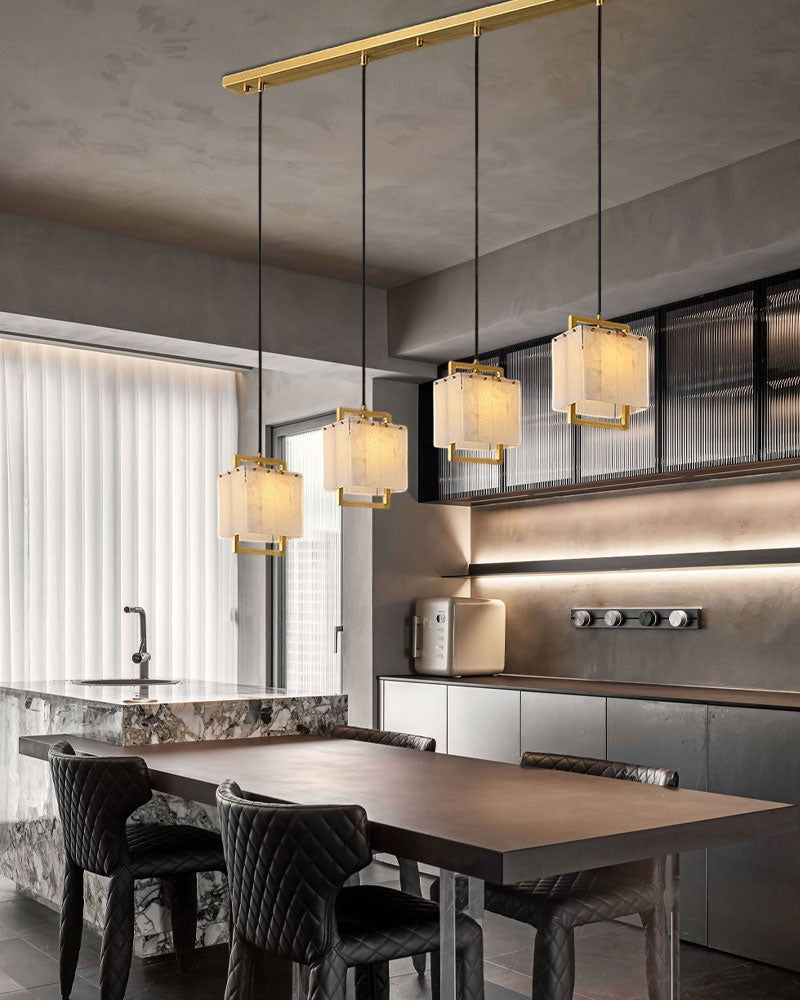 Brass and alabaster pendant lights above a modern kitchen table