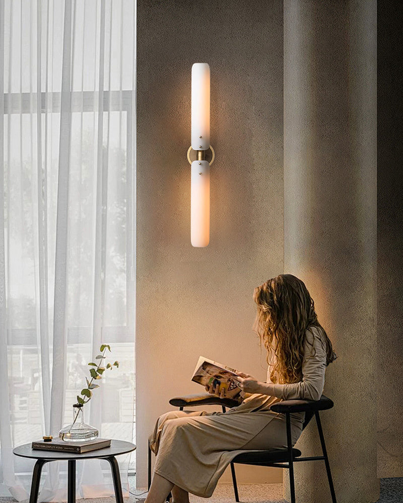 Curved milk glass wall sconce lamp illuminating reading nook in modern living space