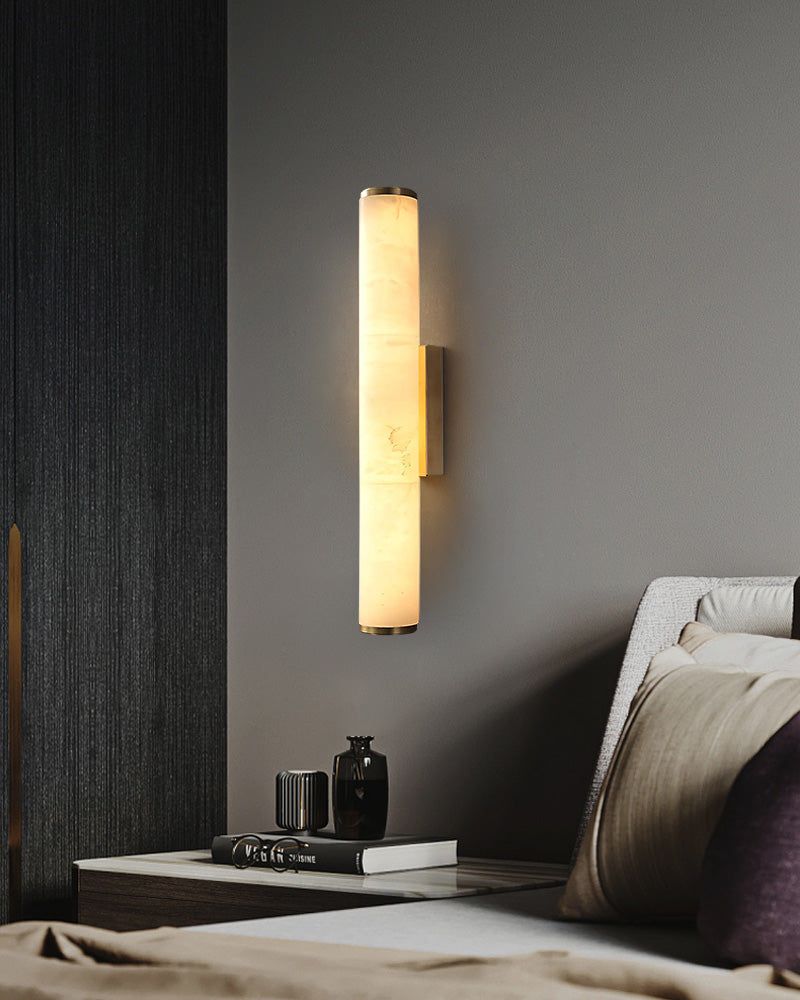 Cylindrical alabaster wall sconce lamp enhancing modern bedroom decor with warm glow