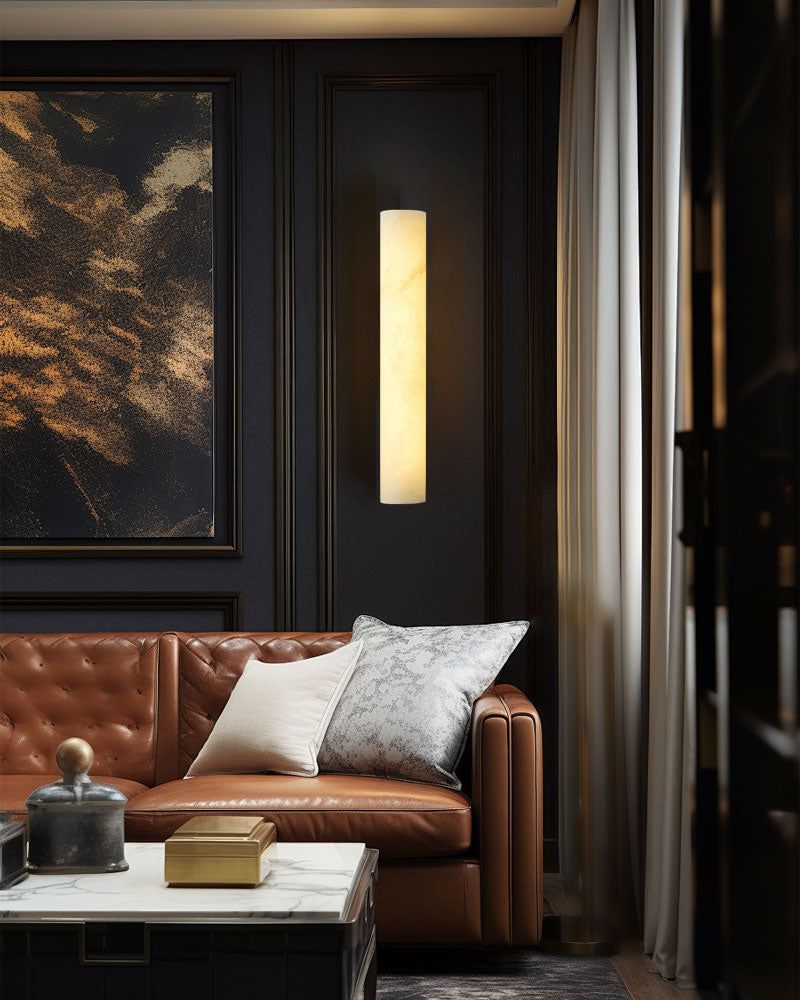 Elegant living room featuring alabaster wall sconce and leather sofa with cushions