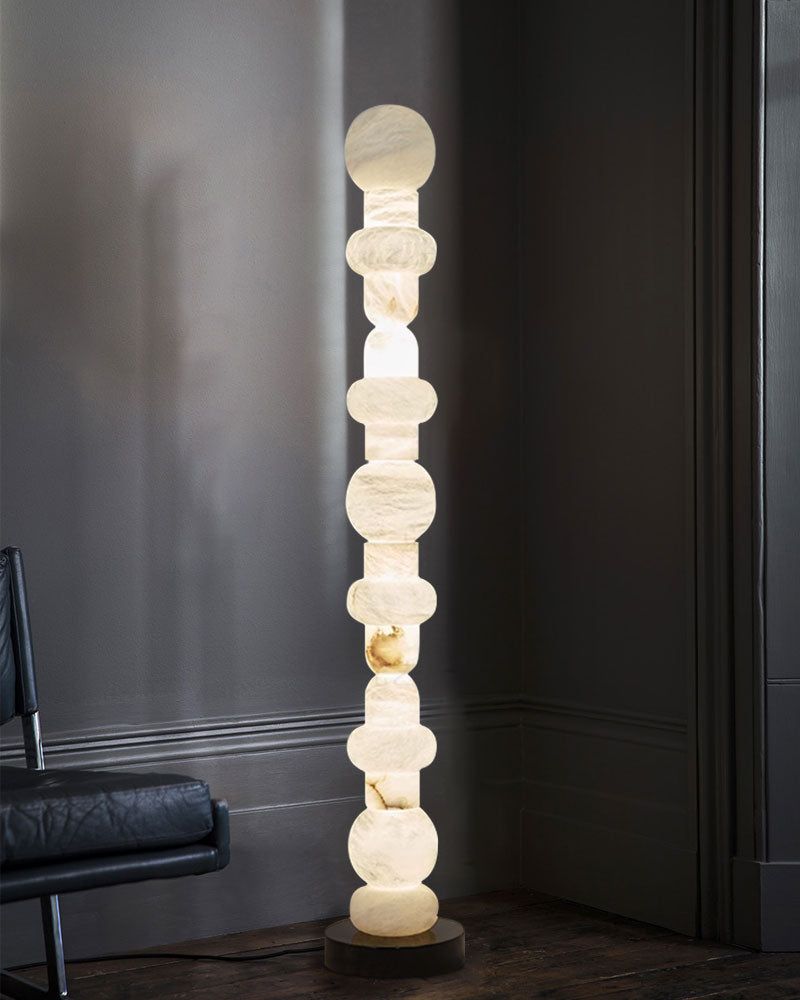 High-standing alabaster floor lamp in contemporary living room corner, warm glow