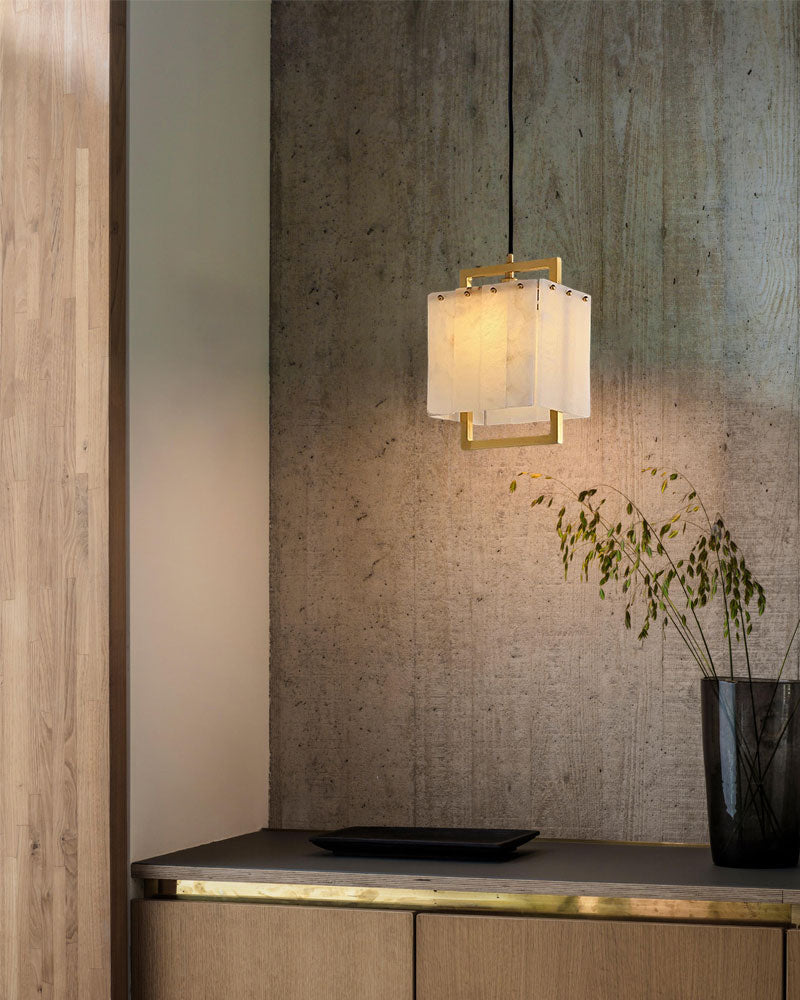 Elegant marble and gold pendant lamp illuminating modern interior with textured wall.