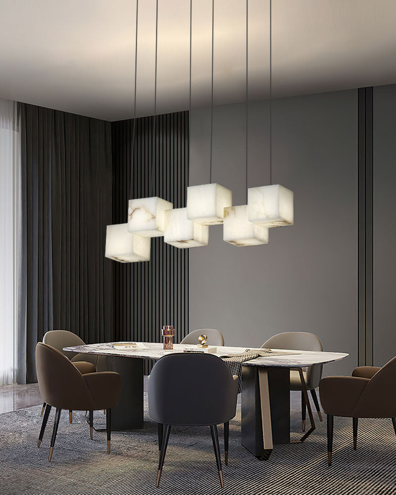 Group of five square white alabaster pendant lights over a sleek modern dining table.