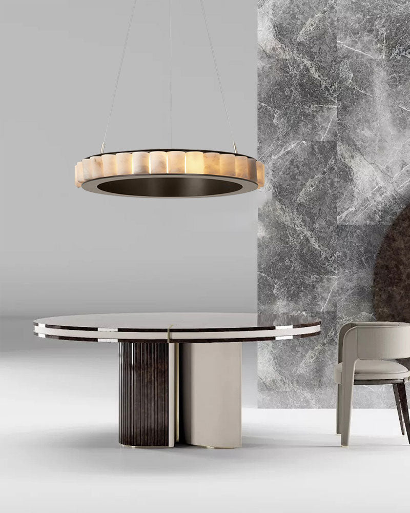 Contemporary round table with striped chandelier and marble wall backdrop.