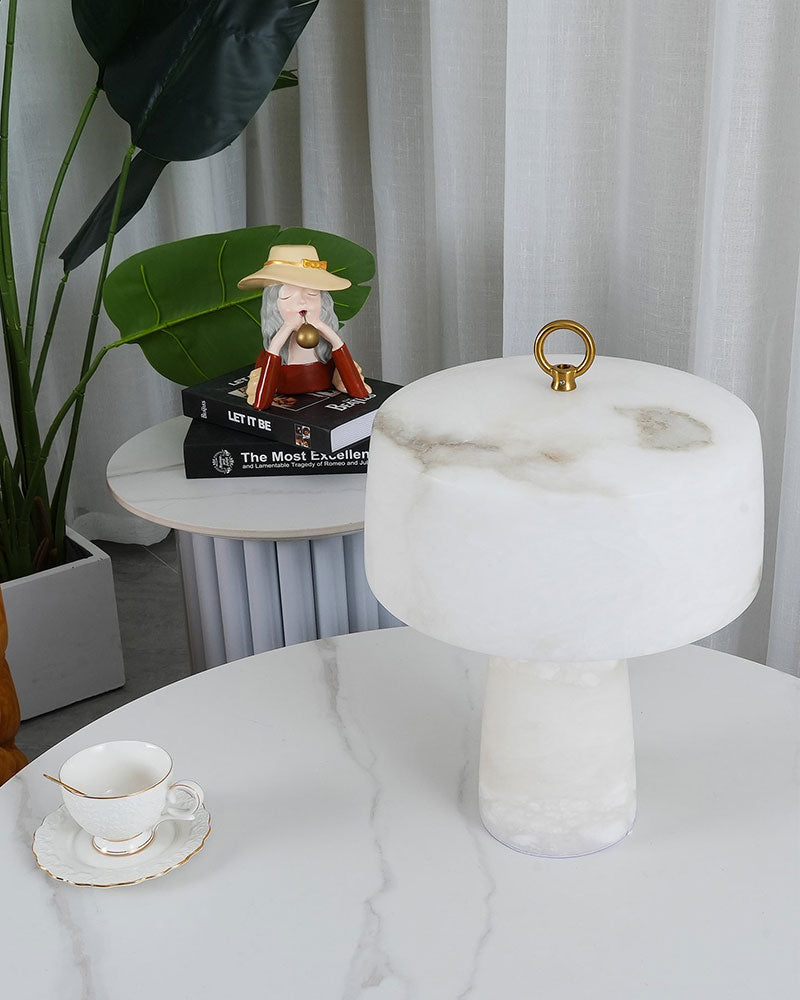 G9 cloud stone table lamp on white marble table with decorative cup and green plant