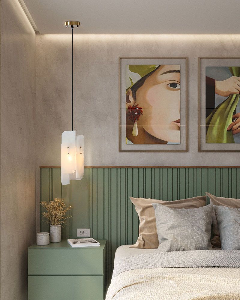 Stylish bedroom featuring green headboard, alabaster pendant lamp, and art decor.