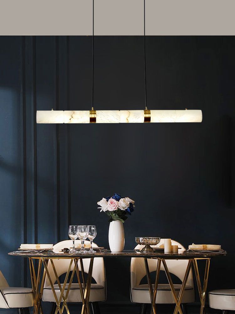 Alabaster LED pendant light above a round dining table with elegant tableware and flowers.