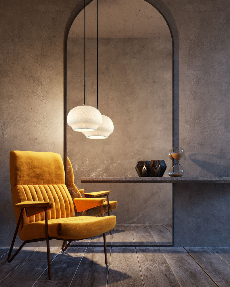 Vintage yellow armchair with alabaster pendant lamps in modern living space.