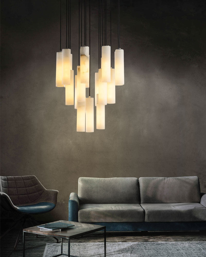 Cluster of alabaster pendant lamps above a modern gray sofa in a stylish living room.