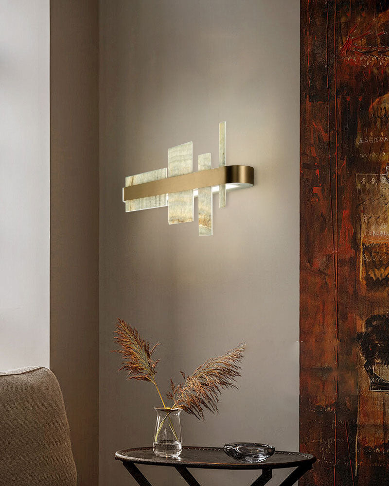 Sleek gold wall lamp illuminating a cozy modern living space with decorative accents.