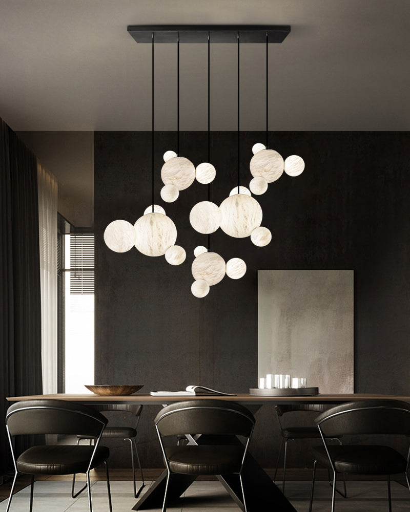 LED Alabaster Pendant Lamp with four different sizes of marble ball supported on metal pole in black/gold