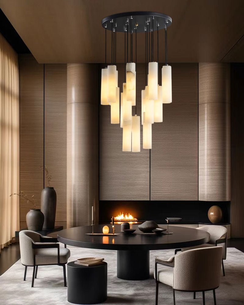 Alabaster pendant lamps over a contemporary black dining table with modern chairs.