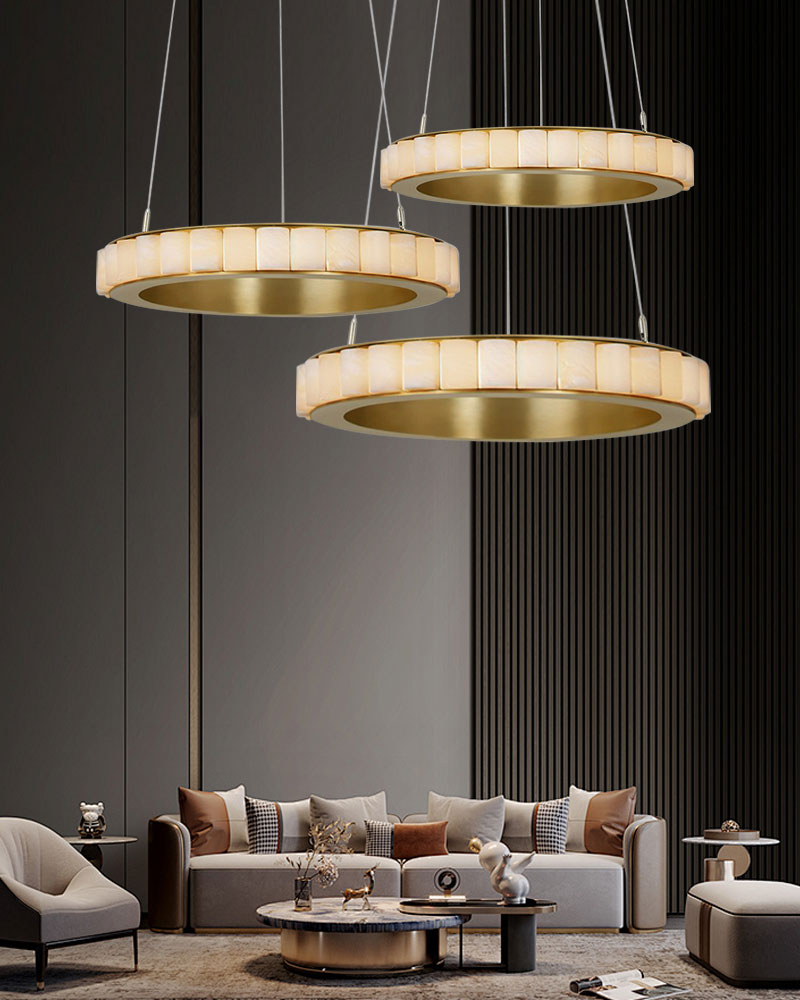 Triple chandelier with alabaster rings above contemporary sofa in stylish living room.