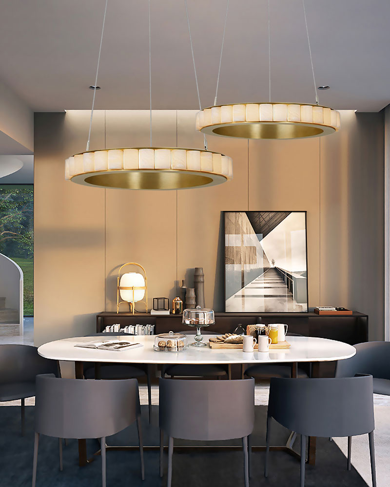 Round triple chandelier with alabaster rings above elegant dining table setup.