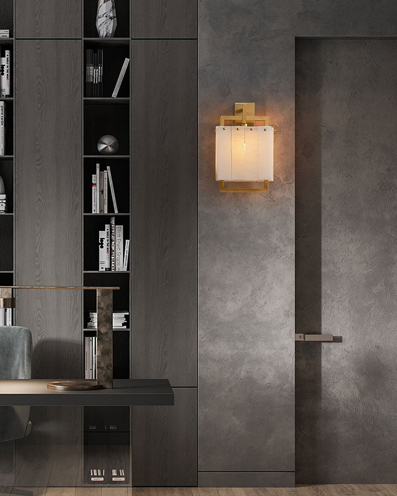 Modern wall lamp with copper frame illuminating contemporary gray setting.