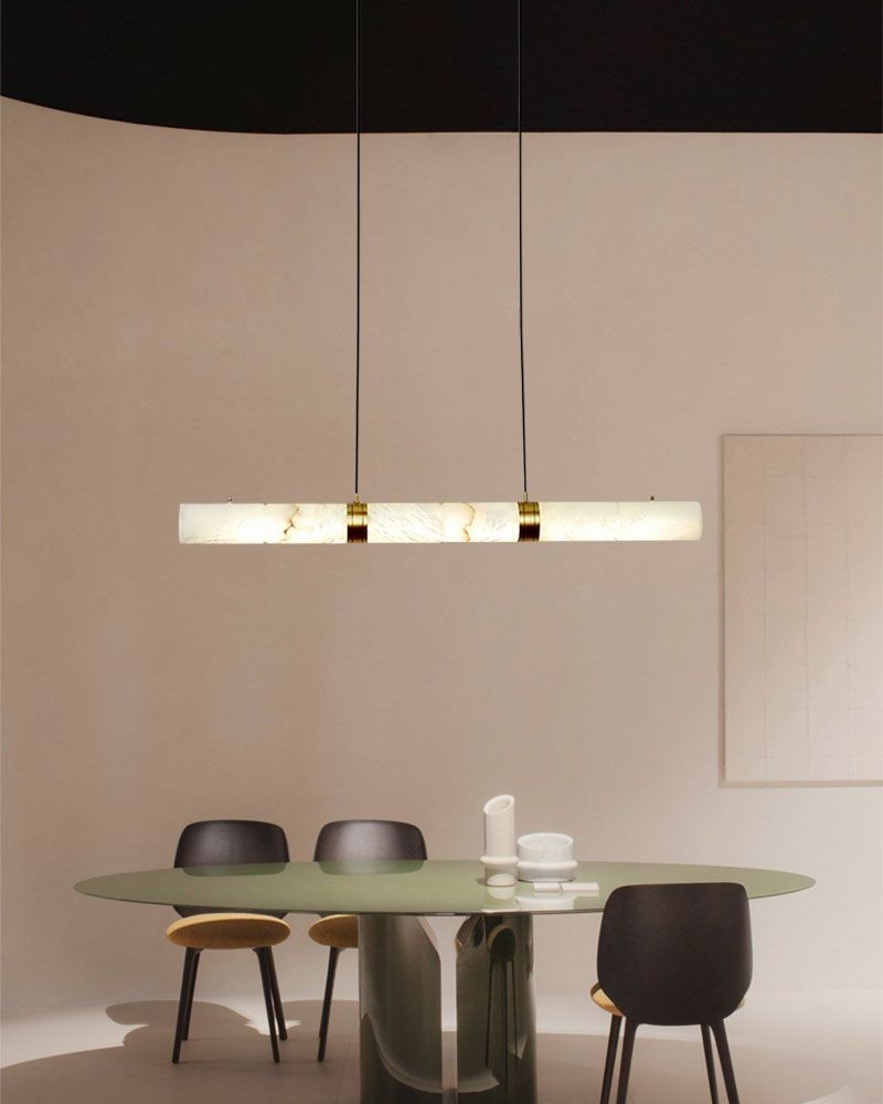 Alabaster LED pendant lamp above a modern round green glass dining table.