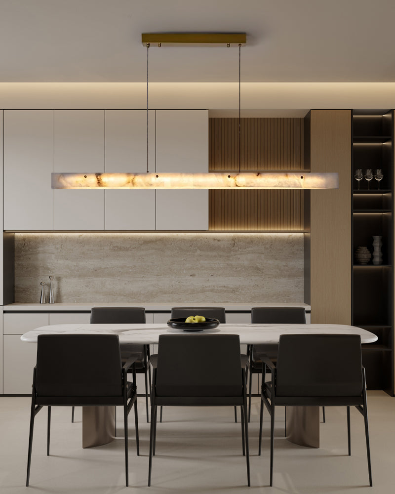 Nordic marble strip pendant light illuminating a modern dining area with dark chairs.