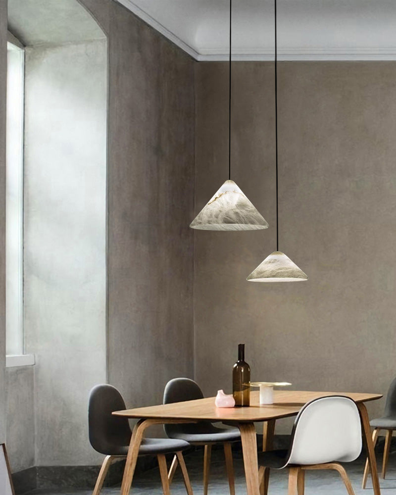 Two conical alabaster pendant lamps over a minimalist wooden dining table