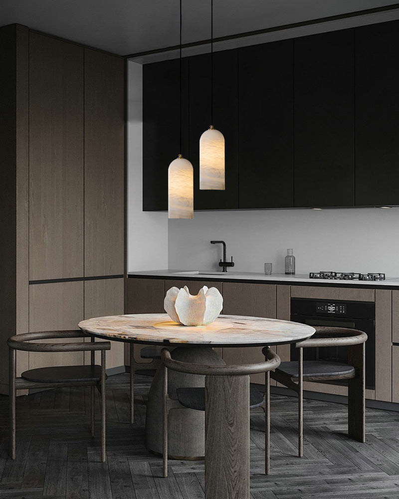 Elegant kitchen featuring a white marble table and two pendant lamps above.