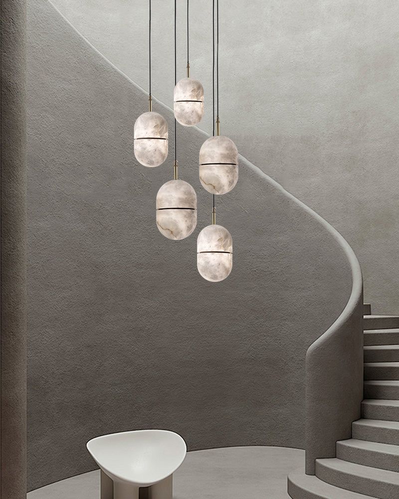 Minimalist alabaster pendant lights above a stylish staircase