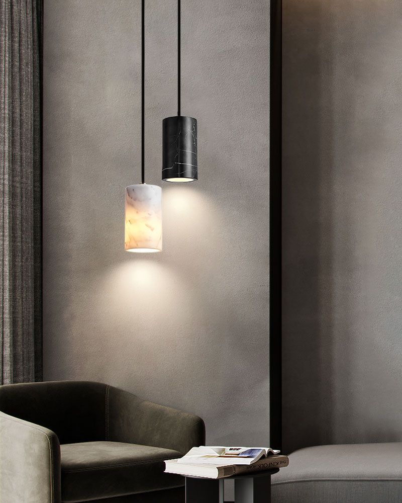 Modern interior with black and white pendant lamps above a green armchair