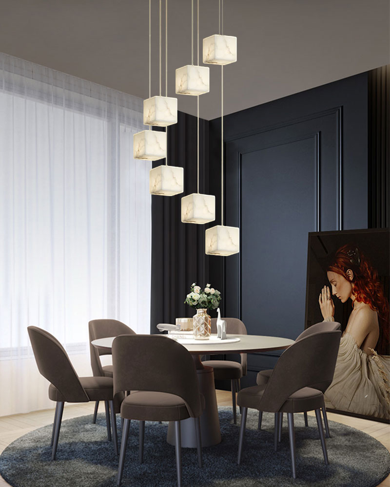 Five white alabaster pendant lights above a round dining table in a modern dining room.