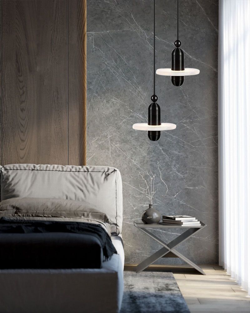 Two black modern pendant lamps above minimalist side table in chic contemporary bedroom