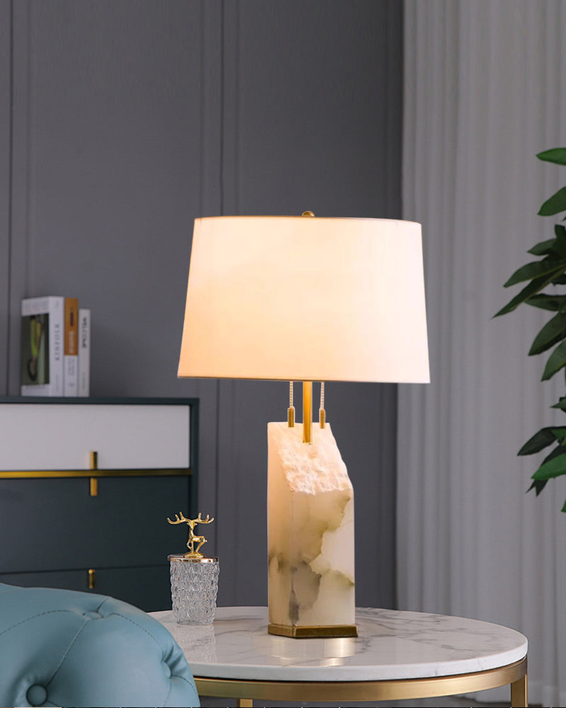 Stylish alabaster table lamp with linen shade on a modern marble side table.